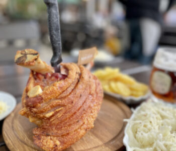 wooden plate with a typical Austrian speciality, knuckle of pork with coleslaw