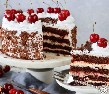 Stock photo showing an close-up view of a homemade, luxury, Black Forest gateau displayed against a marble effect background.